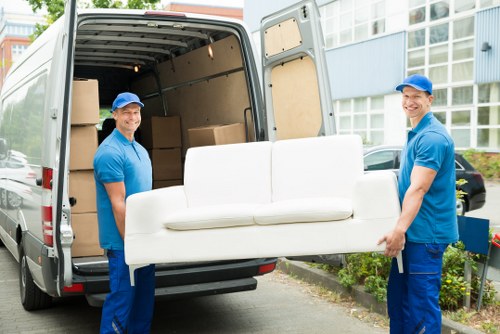 Removal team loading boxes and furniture during a house move in Tooting
